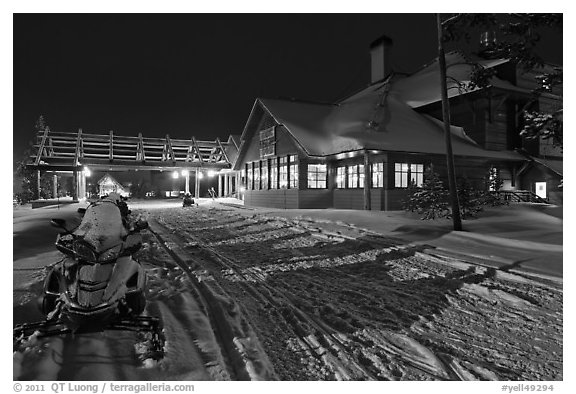 Snowmobiles parked next to Old Faithful Snow Lodge at night. Yellowstone National Park, Wyoming, USA.