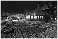 Snowmobiles parked next to Old Faithful Snow Lodge at night. Yellowstone National Park ( black and white)