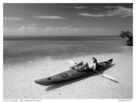 Woman reclining in kayak on shallow waters,  Elliott Key. Biscayne National Park, Florida, USA.