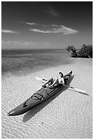 Woman sunning herself on sea kayak parked on shore,  Elliott Key. Biscayne National Park, Florida, USA. (black and white)