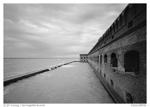 Fort Jefferson massive brick wall overlooking the ocean, cloudy weather. Dry Tortugas National Park (black and white)