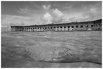 Split view of Fort Jefferson and water with fish. Dry Tortugas National Park, Florida, USA. (black and white)