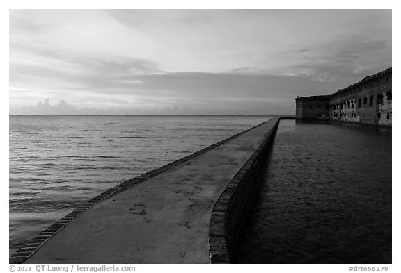 Fort Jefferson moat and walls at sunset with tourists in distance. Dry Tortugas National Park, Florida, USA.