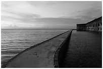 Fort Jefferson moat and walls at sunset with tourists in distance. Dry Tortugas National Park ( black and white)