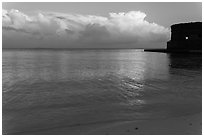 Tropical clouds, beach, and fort at sunrise. Dry Tortugas National Park, Florida, USA. (black and white)