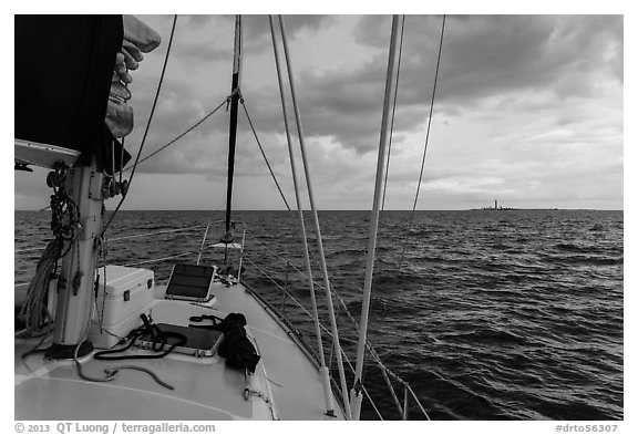 Loggerhead lighthouse seen from sailboat under dark skies. Dry Tortugas National Park (black and white)