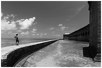 Park visitor looking, Fort Jefferson moat and seawall. Dry Tortugas National Park, Florida, USA. (black and white)