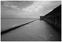 Seascape with fort seawall and moat on cloudy day. Dry Tortugas National Park, Florida, USA. (black and white)