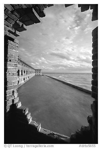 Fort Jefferson seawall and moat, framed by a crumpling embrasures, late afternoon. Dry Tortugas National Park, Florida, USA.