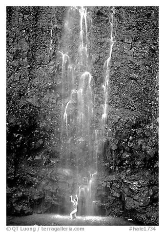 Tourist refreshes herself at the base of Waimoku Falls. Haleakala National Park (black and white)