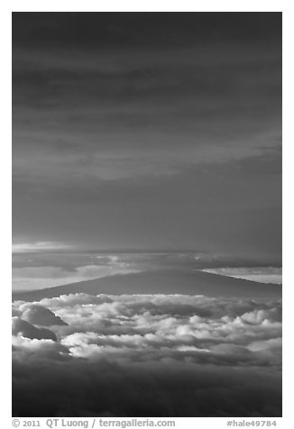 Mauna Kea above and below clouds, sunrise. Haleakala National Park, Hawaii, USA.