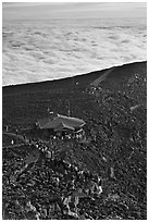 People gather to watch sunrise above sea of clouds. Haleakala National Park ( black and white)