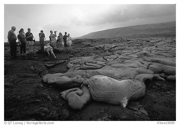 Hikers observe a live lava flow at close distance. Hawaii Volcanoes National Park, Hawaii, USA.