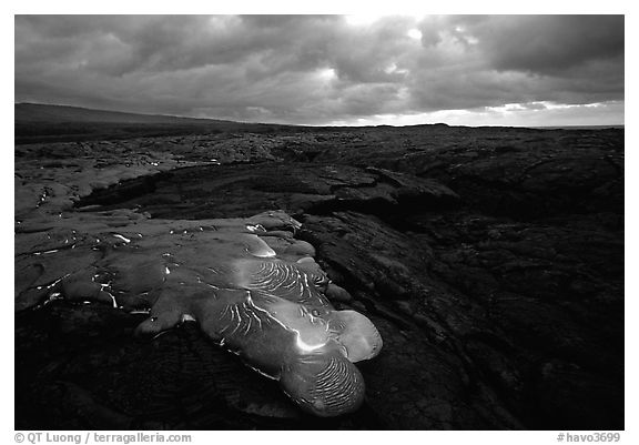 Flowing lava and rain clouds at dawn. Hawaii Volcanoes National Park, Hawaii, USA.