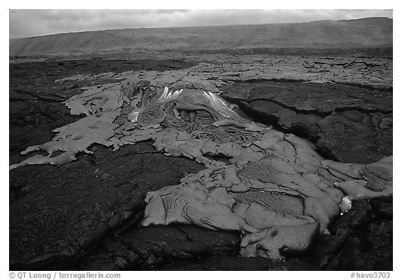 Live hot lava flows over hardened lava. Hawaii Volcanoes National Park (black and white)