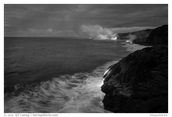 Streams of hot lava flow into the Pacific Ocean at the shore of erupting Kilauea volcano. Hawaii Volcanoes National Park, Hawaii, USA.