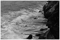 Waves and hot lava dripping from lava bench. Hawaii Volcanoes National Park, Hawaii, USA. (black and white)