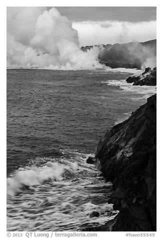 Coast with lava and clouds of smoke and steam produced by lava contact with ocean. Hawaii Volcanoes National Park, Hawaii, USA.