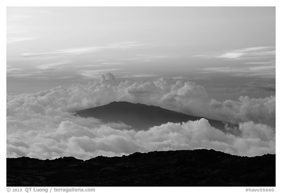 Puu Waawaa summit emerging from sea of clouds at sunset. Hawaii Volcanoes National Park, Hawaii, USA.