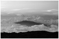 Puu Waawaa summit emerging from sea of clouds at sunset. Hawaii Volcanoes National Park, Hawaii, USA. (black and white)