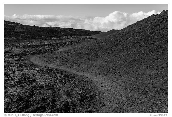 Trail through olivine hill bordering aa lava. Hawaii Volcanoes National Park, Hawaii, USA.