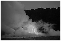 Lava flows cascade down sea cliff at dawn. Hawaii Volcanoes National Park, Hawaii, USA. (black and white)