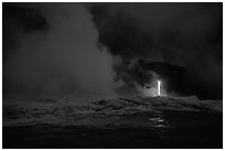 Lava runs down the cliff and goes into the sea at dawn. Hawaii Volcanoes National Park ( black and white)