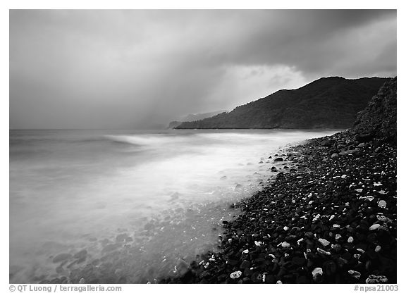 Coastline with dark rocks, light water and storm sky at sunrise, Vatia bay, Tutuila Island. National Park of American Samoa