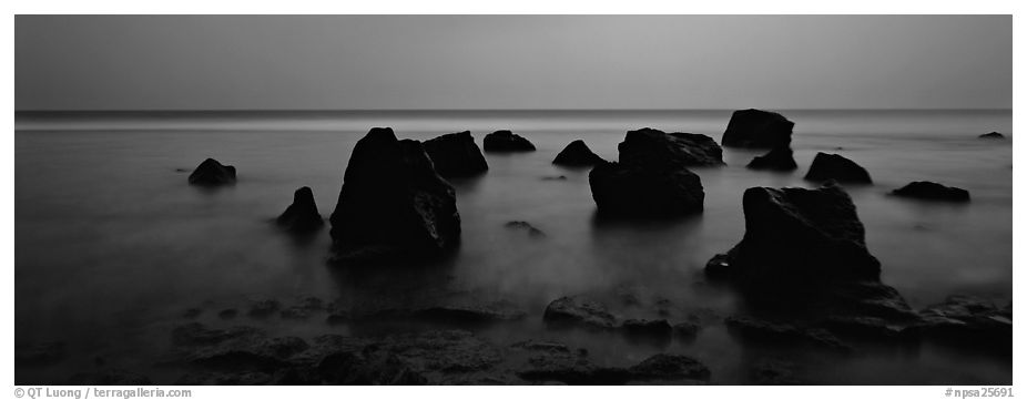 Seascape with boulders in water at dusk. National Park of American Samoa (black and white)