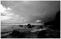 Boulders and coastline at sunrise with rainbow, Siu Point, Tau Island. National Park of American Samoa (black and white)