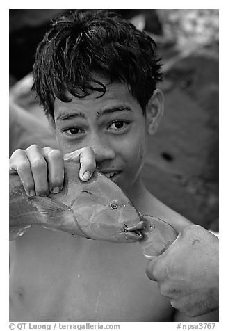 Samoan boy with freshly catched tropical fish, Tau Island. National Park of American Samoa