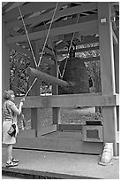 Tourist rings the sacred bell before entering Byodo-In temple. Oahu island, Hawaii, USA ( black and white)