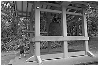 Boy ringing the buddhist bell, Byodo-In temple. Oahu island, Hawaii, USA (black and white)