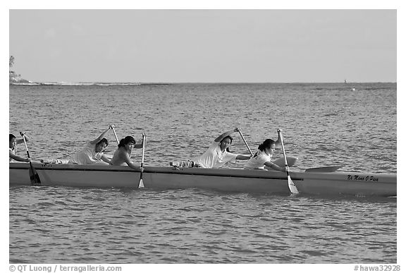 Young women padding a hawaiian outrigger canoe, Maunalua Bay, late afternoon. Oahu island, Hawaii, USA (black and white)