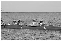 Young women padding a hawaiian outrigger canoe, Maunalua Bay, late afternoon. Oahu island, Hawaii, USA (black and white)