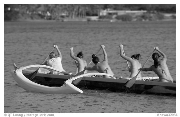 Back view of women in bikini paddling a outrigger canoe, Maunalua Bay, late afternoon. Oahu island, Hawaii, USA (black and white)