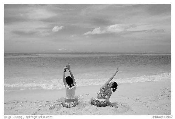 Young women stretching on Waimanalo Beach. Oahu island, Hawaii, USA