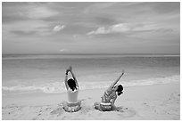Young women stretching on Waimanalo Beach. Oahu island, Hawaii, USA (black and white)