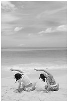 Young women doing gymnastics on Waimanalo Beach. Oahu island, Hawaii, USA (black and white)