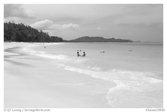 Couple and other bathers in the water, Waimanalo Beach. Oahu island, Hawaii, USA (black and white)