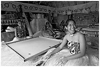 Fiji women sitting at a traditional pool table in vale ni bose (meeting) house. Polynesian Cultural Center, Oahu island, Hawaii, USA (black and white)