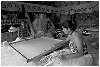 Fiji women playing at a traditional pool table in vale ni bose house. Polynesian Cultural Center, Oahu island, Hawaii, USA (black and white)