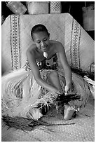 Fiji woman using her feet to tie leaves. Polynesian Cultural Center, Oahu island, Hawaii, USA (black and white)