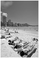 Young women on Waikiki Beach with skyline in the background. Waikiki, Honolulu, Oahu island, Hawaii, USA (black and white)