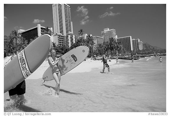 Women carrying surfboards into the water, Waikiki Beach. Waikiki, Honolulu, Oahu island, Hawaii, USA