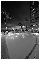 Swimming pool at night, with dance performance, Sheraton hotel. Waikiki, Honolulu, Oahu island, Hawaii, USA (black and white)