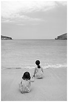 Two girls at the edge of water, Hanauma Bay. Oahu island, Hawaii, USA (black and white)