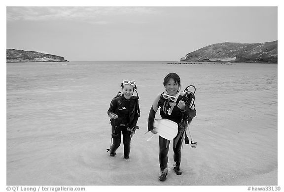 Scuba divers walking out of the water, Hanauma Bay. Oahu island, Hawaii, USA