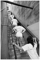 Women climbing a staircase on the Diamond Head summit trail. Oahu island, Hawaii, USA (black and white)