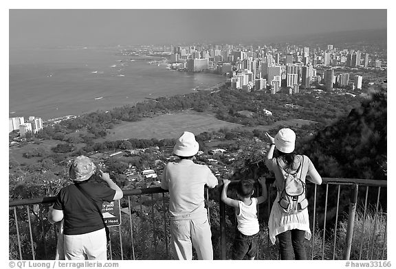 Tourists look at Waikidi from the  Diamond Head crater, early morning. Oahu island, Hawaii, USA